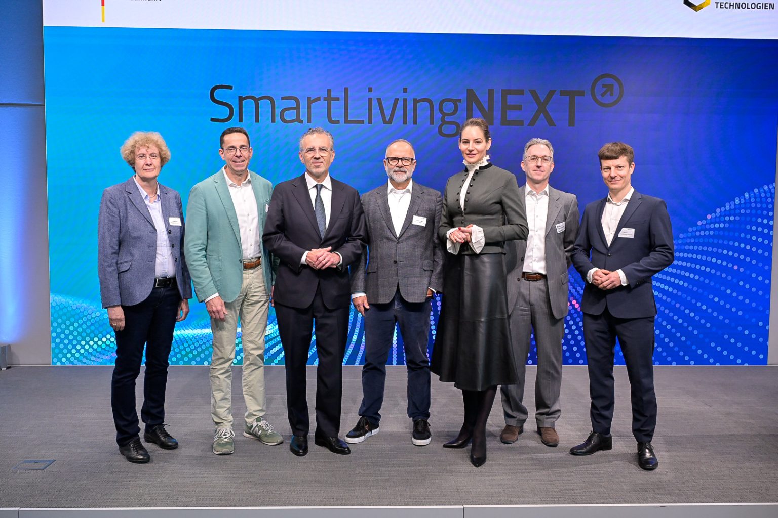 Diskutierten auf der SmartLivingNEXT-Konferenz im Forum Digitale Technologien in Berlin über den Start in den Realbetrieb: Ute Bernhardt, Leiterin des Referats Künstliche Intelligenz im Bundesministerium für Forschung, Technologie und Raumfahrt (BMFTR), Wolfgang Weber, Vorsitzender der ZVEI-Geschäftsführung, Thomas Jarzombek, Parlamentarische Staatssekretär beim Bundesminister für Digitales und Staatsmodernisierung, Michael Schidlack, Principal Researcher bei der Forschungsvereinigung Elektrotechnik beim ZVEI e. V. und Projektleitung des SmartLivingNEXT Leitprojekts, Dr. Alexandra-Gwyn Paetz, Abteilungsleiterin Technologische Souveränität & Innovation, Bundesministerium für Forschung, Technologie und Raumfahrt (BMFTR), Matthias Szymansky, Kompetenzzentrumsleiter Analytics & AI bei Materna Information & Communications SE, Filip Milojkovic, Teamleiter Data Management & AI bei Materna Information & Communications SE (v. l.). Fotograf: Mark Bollhorst.