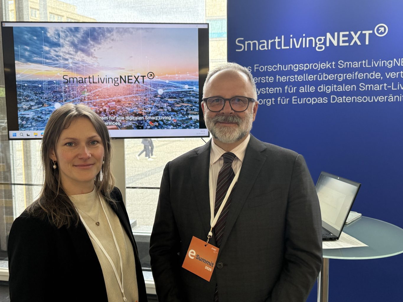 The eSummit 2025 was a complete success for SmartLivingNEXT: Fanni Vespermann, consortium partner Materna, and Michael Schidlack, Principal Researcher at the Research Association for Electrical Engineering (FE) at ZVEI e. V. and consortium leader in SmartLivingNEXT flagship project, at the summit of the electrical and digital industry at the bcc Berlin Congress Center.