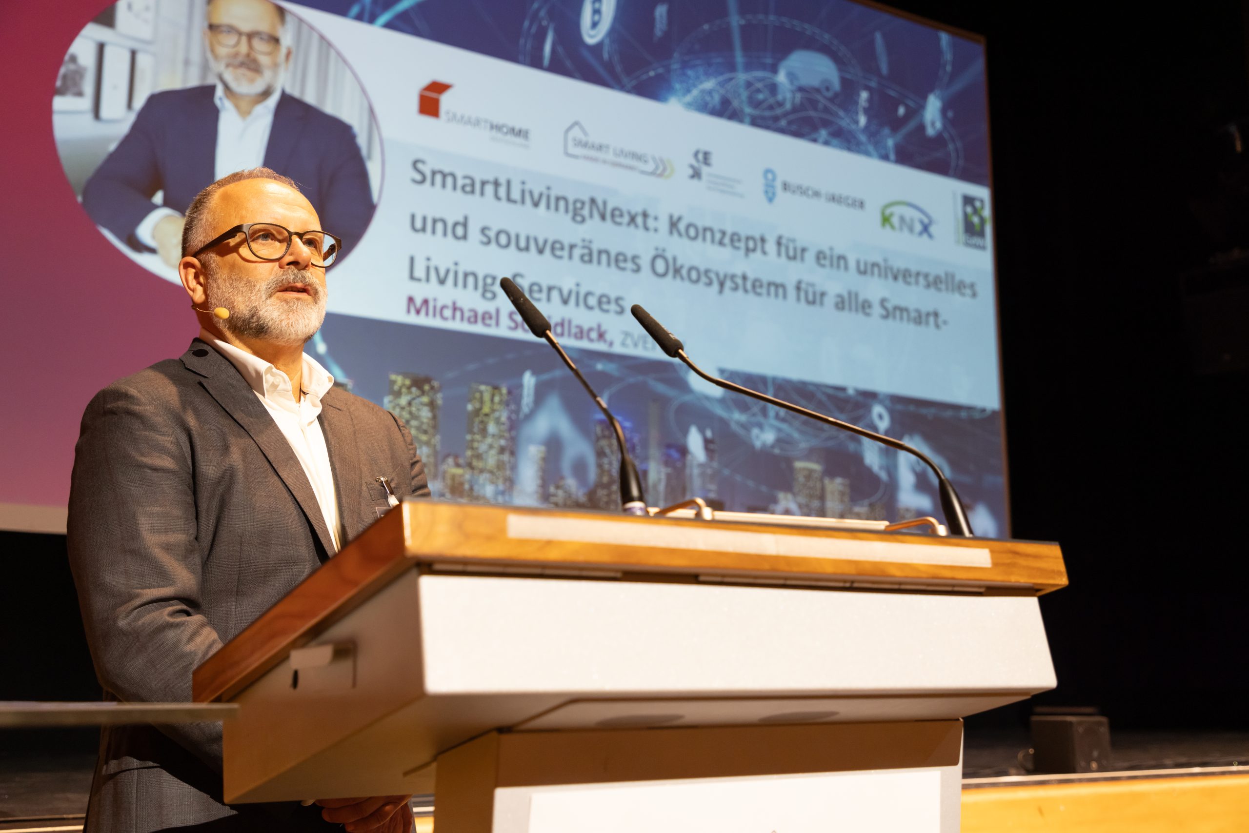 SmartLivingNEXT auf dem Smart Living Summit 2024: Michael Schidlack stellte in Erding das Konzept eines universellen, souveränen und vertrauenswürdigen Ökosystems für alle digitalen Smart-Living-Services vor.